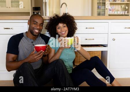 Un jeune couple heureux assis dans la cuisine Banque D'Images