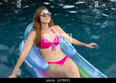 Jeune femme se détendre dans la piscine Banque D'Images
