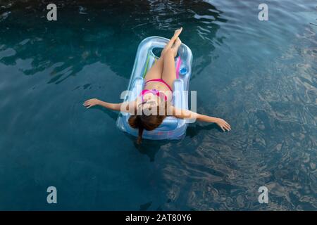Jeune femme se détendre dans la piscine Banque D'Images