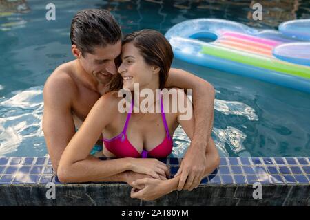 Un jeune couple heureux se relaxant dans la piscine Banque D'Images