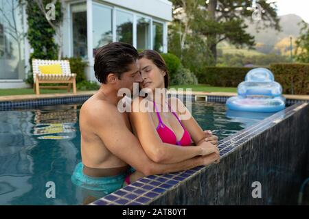 Un jeune couple heureux se relaxant dans la piscine Banque D'Images