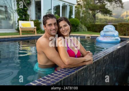 Un jeune couple heureux se relaxant dans la piscine Banque D'Images