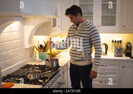 Jeune homme cuisine à la maison Banque D'Images