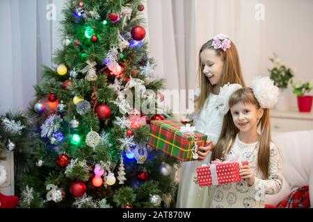 Des enfants joyeux dans l'arbre de Noël avec des cadeaux pour les vacances de Noël. Banque D'Images