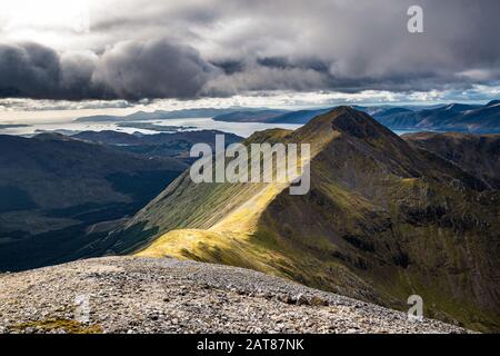 Le sommet de Sgorr Dhonuill (Beinn a'Bheithir) lors d'une journée d'automne avec des nuages qui se rassemblent le long de la côte. Glencoe, Écosse. Banque D'Images