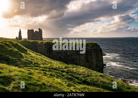 Paysage côtier du nord de l'Écosse avec des ruines du château Sinclair Girnigoe, près de Wick, au coucher du soleil. Banque D'Images