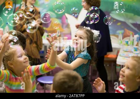 Enfants à la fête. Des bulles de savon s'affichent. Fête des enfants. Pour faire éclater la bouée de savon Banque D'Images