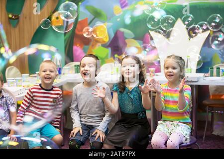 Enfants à la fête. Des bulles de savon s'affichent. Fête des enfants. Pour faire éclater la bouée de savon Banque D'Images