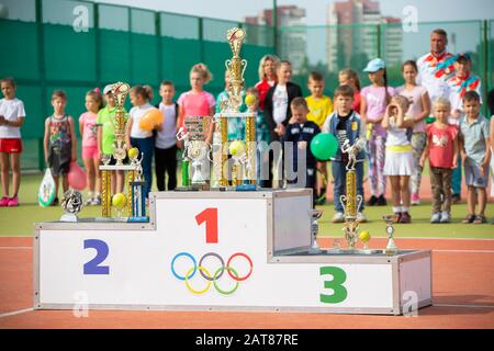 Biélorussie, la ville de Gomil, 08 septembre 2018. Courts de tennis ouverts. Socle sportif avec tasses sur un fond d'athlètes enfants flous. Banque D'Images