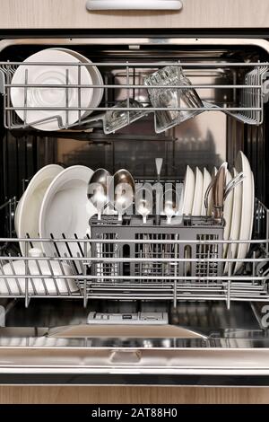 Nettoyez la vaisselle dans un fragment d'un lave-vaisselle intégré à l'armoire, à l'avant, dans un style vertical. Banque D'Images