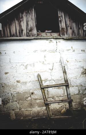 Ancien escalier en bois près du mur du bar dans une cour rurale. Banque D'Images