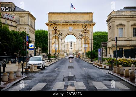 Rue Foch menant à la porte du Peyrou par une matinée grise humide avec voiture passant par la porte. Montpellier, France, 2 Mai 2019 Banque D'Images