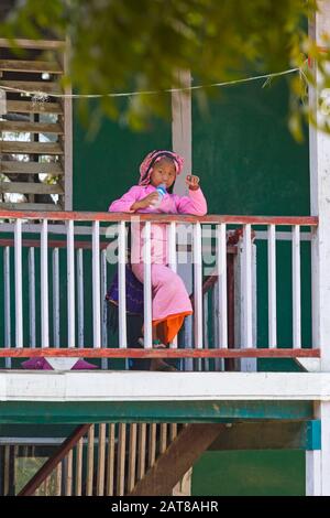 Jeune novice non debout sur le balcon de l'eau potable à Aung Myae Oo monastique Free Education School, Sagaing, Mandalay Myanmar (Birmanie) Asie en février Banque D'Images