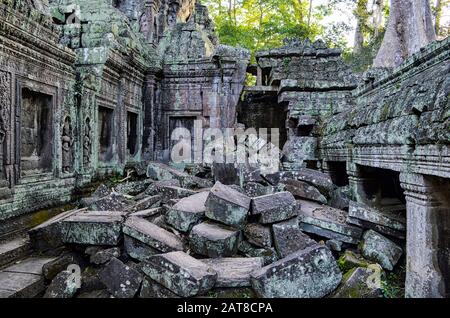 Ankor Wat, temple historique khmer du XIIe siècle et site du patrimoine mondial de l'UNESCO. Arches et blocs de pierre sculptés, maçonnerie tombée et structures étant ov Banque D'Images