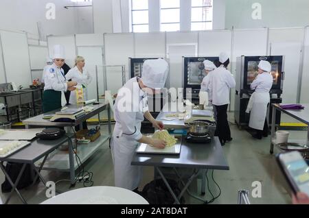 Jeune cuisinier prépare les aliments en compétition Banque D'Images