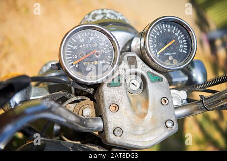 Vue rapprochée des instruments avant d'une vieille moto sale et rouillée garée dans une petite ville des Philippines Banque D'Images