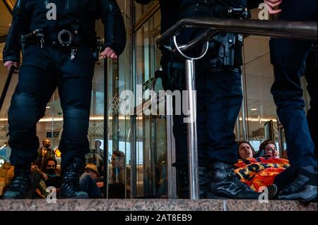Un groupe d'activistes XR collés aux portes du cristal pendant la campagne. Une vingtaine d'activistes du groupe Rébellion de l'extinction ont montré au siège de Shell dans le cadre de la campagne Shell doit tomber, qui se déroule toute la semaine dans tout le pays. Certains militants de l'extinction se sont collés aux fenêtres et aux portes en cristal du bâtiment. Après avoir refusé de quitter le lieu, la plupart d'entre eux ont été arrêtés par la police. Banque D'Images