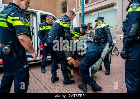 Un militant du XR arrêté par la police pendant la campagne. Une vingtaine d'activistes de la rébellion de l'extinction du groupe se sont manifestés au siège de Shell dans le cadre de la campagne que Shell doit faire, qui a lieu toute la semaine dans tout le pays. Certains militants de l'extinction se sont collés aux fenêtres et aux portes en cristal du bâtiment. Après avoir refusé de quitter le lieu, la plupart d'entre eux ont été arrêtés par la police. Banque D'Images