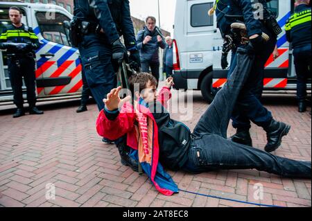 Un militant de la XR est vu traîner à travers le sol pendant la campagne. Une vingtaine d'activistes de la rébellion de l'extinction du groupe ont montré au siège de Shell dans le cadre de la campagne que Shell doit tomber, qui se déroule toute la semaine dans tout le pays. Certains militants de l'extinction se sont collés aux fenêtres et aux portes en cristal du bâtiment. Après avoir refusé de quitter le lieu, la plupart d'entre eux ont été arrêtés par la police. Banque D'Images