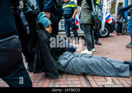 Un militant de la XR est vu traîner à travers le sol pendant la campagne. Une vingtaine d'activistes de la rébellion de l'extinction du groupe ont montré au siège de Shell dans le cadre de la campagne que Shell doit tomber, qui se déroule toute la semaine dans tout le pays. Certains militants de l'extinction se sont collés aux fenêtres et aux portes en cristal du bâtiment. Après avoir refusé de quitter le lieu, la plupart d'entre eux ont été arrêtés par la police. Banque D'Images
