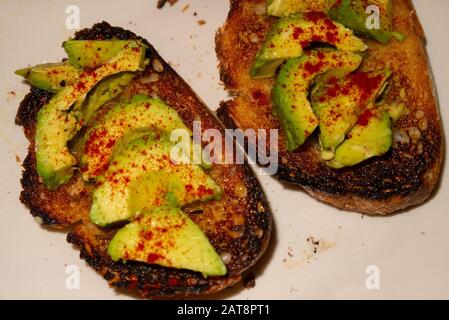 Avocat garni de paprika sur pain grillé au beurre Banque D'Images