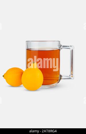 Verre de thé et de citrons sur fond blanc. Banque D'Images