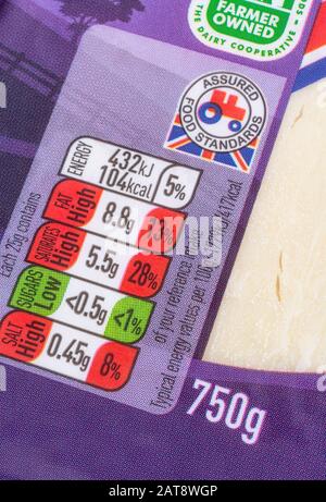 ASDA Cheddar fromage emballages alimentaires affichant la boîte d'information sur la nutrition alimentaire, la teneur en matières grasses alimentaires, la teneur en sel. Logo du tracteur standard Food Assured. Banque D'Images