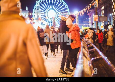 Couple embrassant la Saint Valentin. Jeune couple romantique s'amuser à l'extérieur en hiver. Saint-Valentin Journée à la patinoire de la ville. Vacances nouvel an Banque D'Images