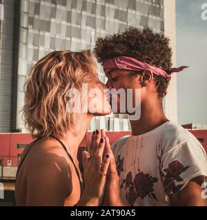 Cœur en mouvement. Couple de jeunes hommes et femmes dans la ville sur le fond d'un gratte-ciel. Saint Valentin et concept d'amour. Banque D'Images