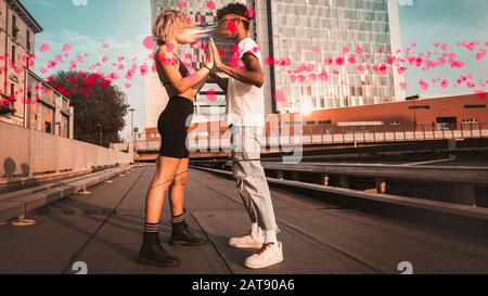 Cœur en mouvement. Couple de jeunes hommes et femmes dans la ville sur le fond d'un gratte-ciel. Saint Valentin et concept d'amour. Banque D'Images