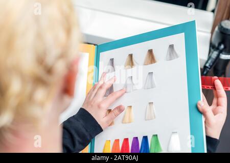 Femme en choisissant la couleur des cheveux à partir de la palette de couleurs dans le salon de beauté, gros plan. Banque D'Images