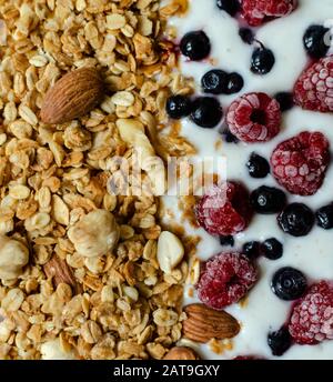 petit déjeuner sain, granola avec yaourt et framboises et bleuets congelés, gros plan Banque D'Images