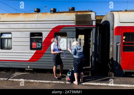 Provodnitsa (préposés aux trains) contrôlant le billet d'un passager sur l'express trans-sibérien à Yaroslavl Banque D'Images