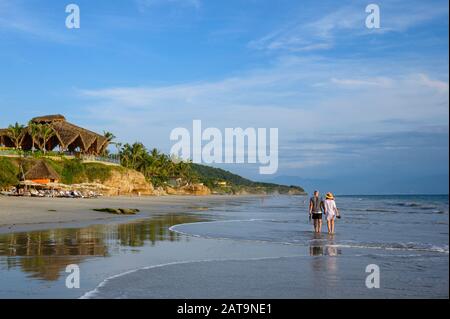 Couple Marchant Sur Playa Destiladera À Marival Armony Resort , Riviera Nayarit, Mexique. Remarque : le couple a donné l'autorisation de prendre des photos. Banque D'Images