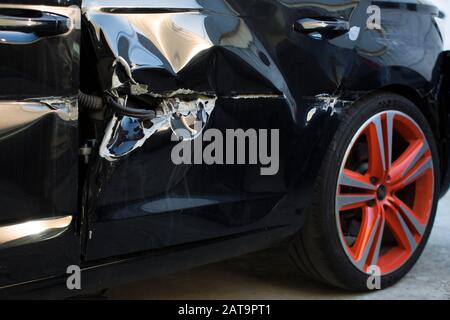 porte de voiture noire cassée, voiture après un accident une porte rayée avant la peinture Banque D'Images