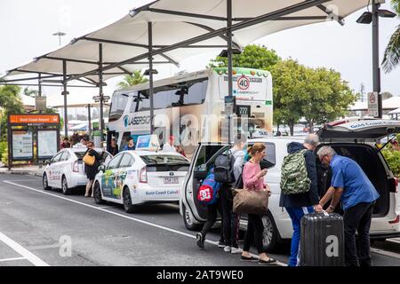 Les voyageurs de la Gold Coast à la station de taxi de l'aéroport où le chauffeur de taxi aide à charger des valises dans le taxi, Queensland, Australie Banque D'Images