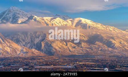Panorama Mont Timpanogos sur des maisons avec neige en hiver et illuminé par le coucher de soleil doré Banque D'Images