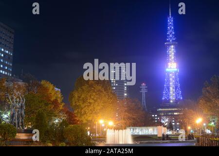 Sapporo, Japon - 30 octobre 2019: La tour de télévision Sapporo brille comme une balise bleue dans le parc Odori pendant une nuit d'automne froide Banque D'Images