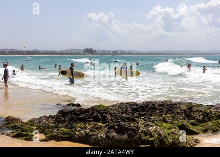 Surfeurs dans l'océan à la plage Pass à Byron Bay, NSW, Australie Banque D'Images