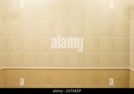 Mur de salle de bains, décorées avec des carreaux de céramique beige carré avec un modèle en marbre des zones claires et sombres. Fond architectural Banque D'Images