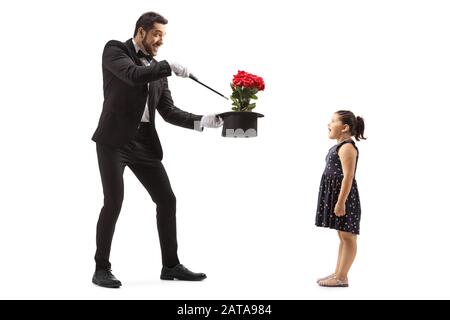 Une photo pleine longueur d'un magicien faisant des fleurs apparaissent d'un chapeau et une petite fille surprise regardant isolé sur fond blanc Banque D'Images