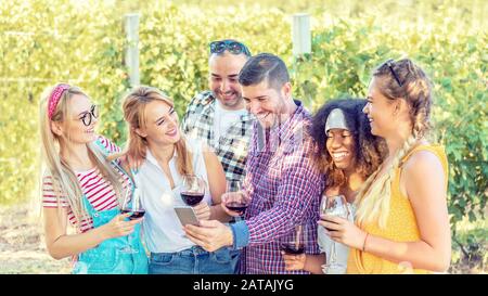 Un groupe joyeux de meilleurs amis aiment boire du vin à la campagne vignoble pique-nique fête tout en regardant le selfie des réseaux sociaux sur le téléphone mobile Banque D'Images
