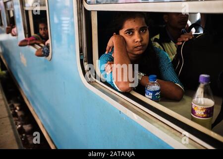 Une jeune fille assise sur un train au Sri lanka et sourig. Banque D'Images