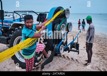 Les pêcheurs locaux tirent les filets de l'océan à l'aide d'un tracteur. Trincomalee, Sri Lanka Banque D'Images