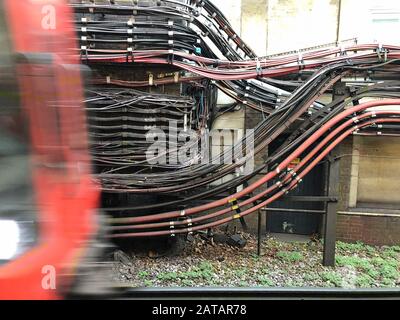 Londres, Royaume-Uni - 26 janvier 2020 : un train souterrain arrive à côté du câblage électrique de la station de métro London Edgware Road. Banque D'Images