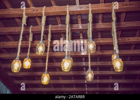 classique différentes ampoules rétro accrochées sur fond de mur de brique la nuit . plafond en bois . câble . Superbe décor rétro de lampe lumineuse de luxe Banque D'Images