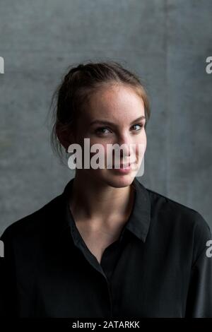 Jeune Femme Graning Avec La Tête Légèrement Tournée Banque D'Images