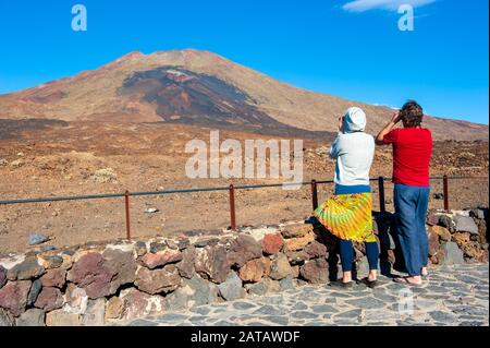 Île des Canaries TENERIFE, ESPAGNE - 24 DEC, 2019: Touristes avec des jumelles regardant la lave violette et brune des ouïes inférieures du volcan Pico vie Banque D'Images