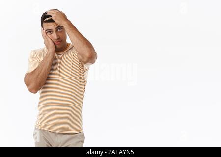 OH mon dieu, pourquoi moi. Pressés et agacés jeunes nourris de petit ami, la tête va exploser, envelopper le visage et la stare intense et gêné appareil photo, écouter l'attention Banque D'Images