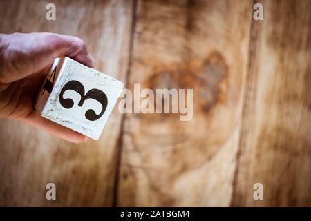 Numéro 3 - une main tenant un bloc blanc avec le numéro trois sur la table en bois vintage Banque D'Images